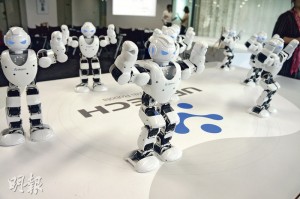 機械人表演「街舞」，動作整齊劃一，顯示同一指令可以同時傳達給多個機器人的技術。（明報記者攝）